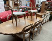 A modern pine extending dining table together with eight balloon back dining chairs a sideboard and