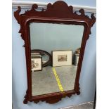 A George III style mahogany wall mirror with a scrolling top
