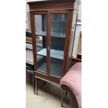 An Edwardian mahogany display cabinet with a pair of glazed doors and glazed sides on square