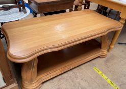 A 20th century light oak occasional table with a shaped top carved legs and an undertier