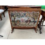 An oak framed fire screen with hunting scene woolwork panel