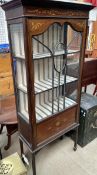 An Edwardian mahogany display cabinet with a moulded cornice above a glazed door and sides on