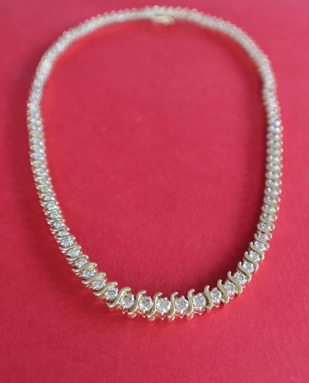 A 14ct yellow gold diamond set necklet set with one hundred and five round brilliant cut diamonds,