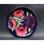 A Moorcroft pottery plate decorated in the Clematis pattern,