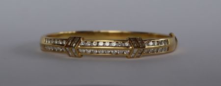 An 18ct yellow gold diamond set hinged bangle, set with two rows of brilliant cut diamonds,