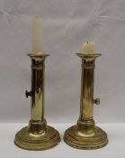 A pair of brass candlesticks, with fixed sconces, and sliding ejectors on a turned foot, 18.