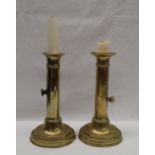 A pair of brass candlesticks, with fixed sconces, and sliding ejectors on a turned foot, 18.