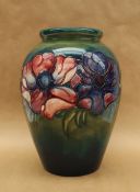 A Moorcroft pottery vase, decorated in the anemone pattern to a green ground,