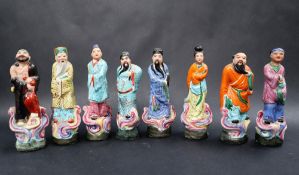 A set of eight Chinese porcelain figures of Sages and immortals, on oval bases,