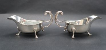 A Pair of George VI silver sauce boats with scalloped edge and three legs with pad feet and