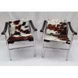A pair of cow hide and chrome elbow chairs after Le Corbusier LCI,