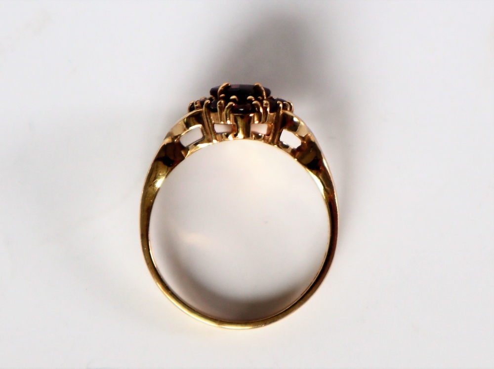 A 9ct yellow gold garnet cluster ring, set with a pointed central garnet and round faceted garnets, - Image 3 of 4