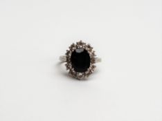 A diamond cluster ring, the central oval faceted stone possible a colour change sapphire,