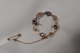 A 15ct gold brooch, set with blue sapphires and seed pearls, of circular form, approximately 3.