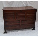 An 18th century oak coffer, the planked rectangular top above a multiple panelled front on stiles,