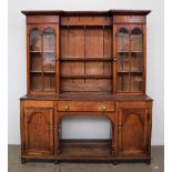 A 19th century oak dresser, the moulded cornice above central shelves and glazed cupboards,