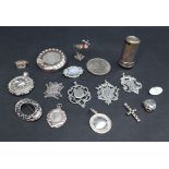 A collection of silver medallions, heart shaped locket, etc,