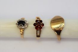 A 9ct gold signet ring together with a 9ct gold garnet set ring and a gem set 9ct gold ring