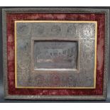 A white metal plaque decorated to the centre with a scene of the Last Supper,