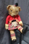 A Merrythought Bingie teddy bear dressed as a highlander in corduroy jacket,