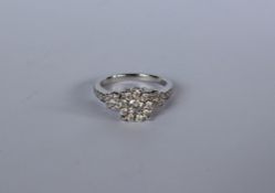 A diamond cluster ring set with a central round old cut diamond surrounded by nine round old cut