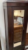 A 20th century oak wardrobe with a mirrored door and drawer to the base together with an oak chest