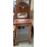 An Edwardian mahogany music cabinet with a shell carved mirror back,