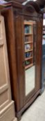 An Edwardian walnut wardrobe with a mirrored door