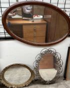 An oval wall mirror together with two other mirrors