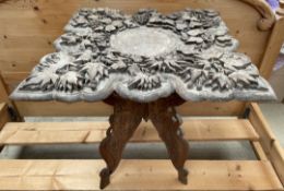 A carved Anglo Indian occasional table with a folding base