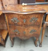 A 20th century burr walnut chest with two drawers on shaped legs and sabot feet,