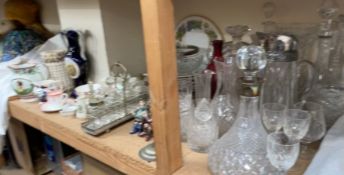 A silver topped and glass ships decanter together with other decanters, drinking glasses,