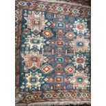 A rug with a light blue ground and geometric patterns together with two prayer rugs