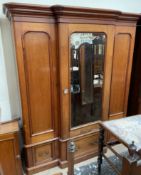 A Victorian mahogany triple wardrobe, the moulded cornice above a central mirrored door,