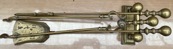 A set of three brass fire irons and an andiron