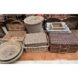 A wicker laundry basket together with wicker bowls,
