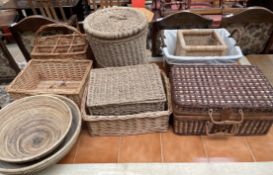 A wicker laundry basket together with wicker bowls,