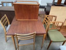 A mid 20th century teak extending dining table together with a set of four dining chairs,
