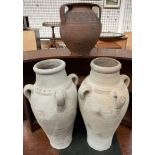 A pair of pottery three handled vases together with a twin handled vase
