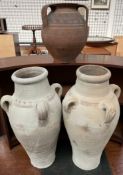 A pair of pottery three handled vases together with a twin handled vase