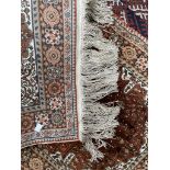 A small Persian silk rug, with a cream ground, central medallion and guard stripes,