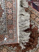 A small Persian silk rug, with a cream ground, central medallion and guard stripes,