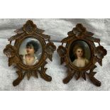 A pair of black forest easel frames carved with flowers and leaves together with a pair of