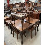 An Edwardian walnut extending dining table together with eight dining chairs with shell carved