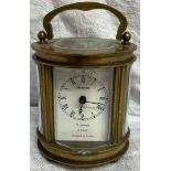 A miniature French brass carriage clock of oval form,