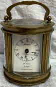 A miniature French brass carriage clock of oval form,