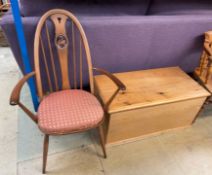 An Ercol Swan back elbow chair together with a pine trunk