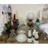 A collection of oil lamps, shades,