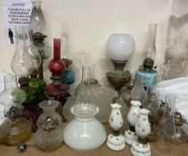 A collection of oil lamps, shades,