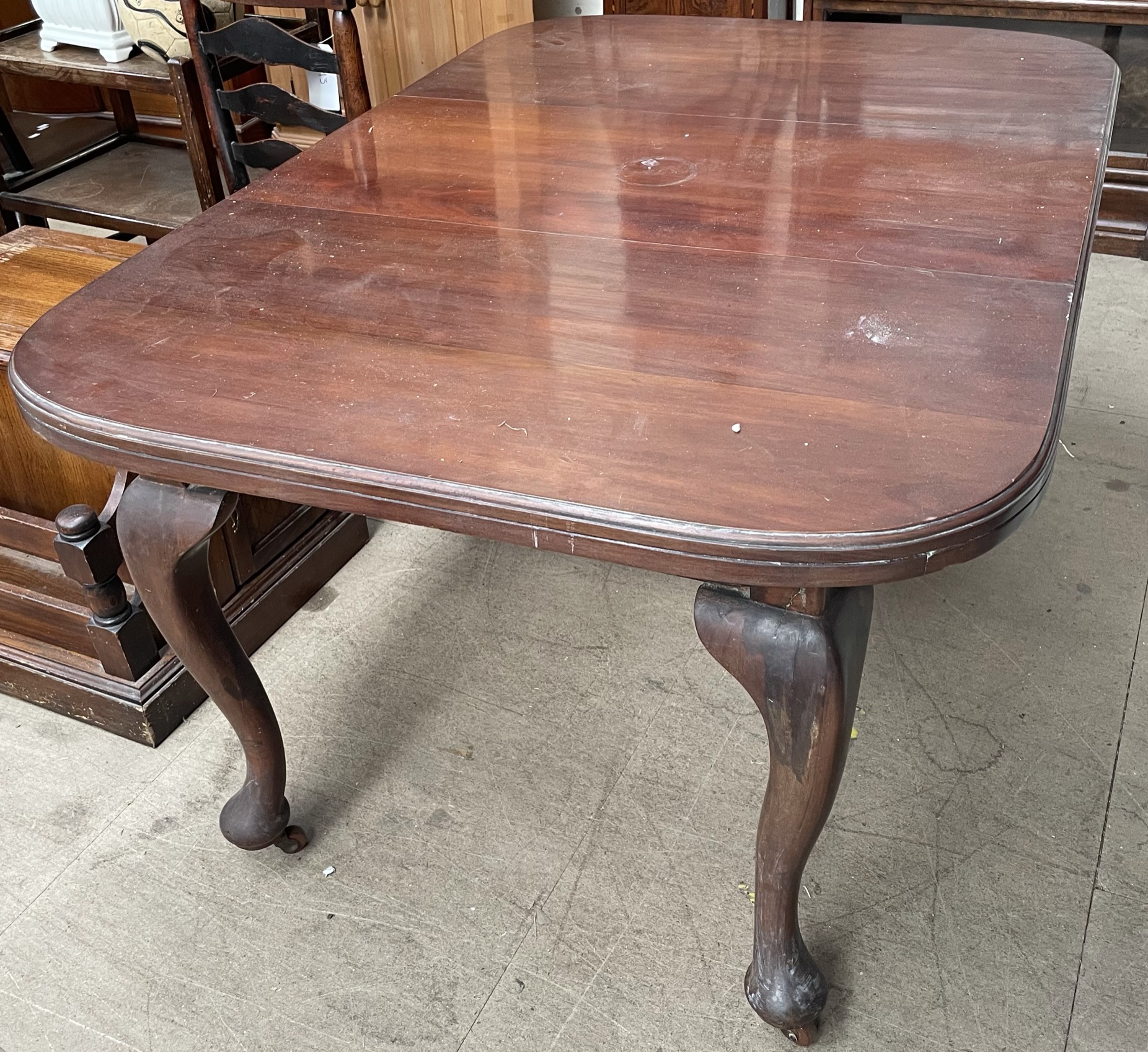 A mahogany extending dining table on cabriole legs and pad feet and casters